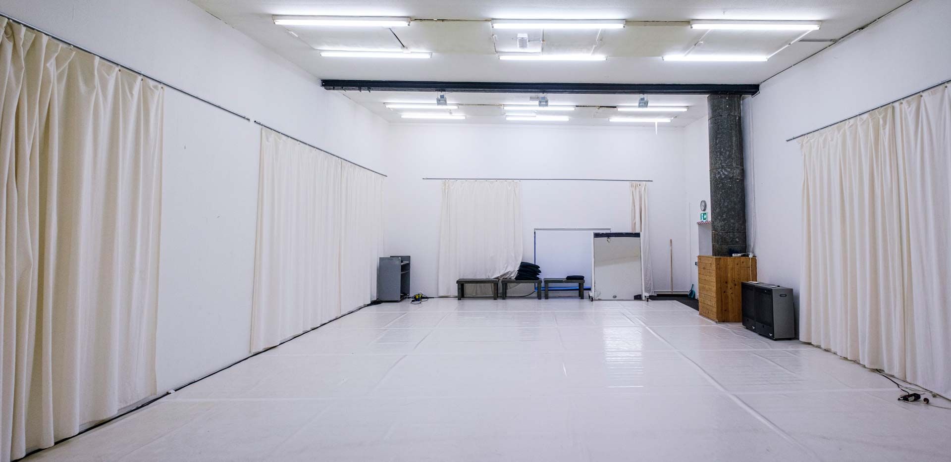 Studio 2 / White Cube bei Barnes Crossing mit hellem Tanzboden, weißen Wänden und Bänken an der Rückwand.